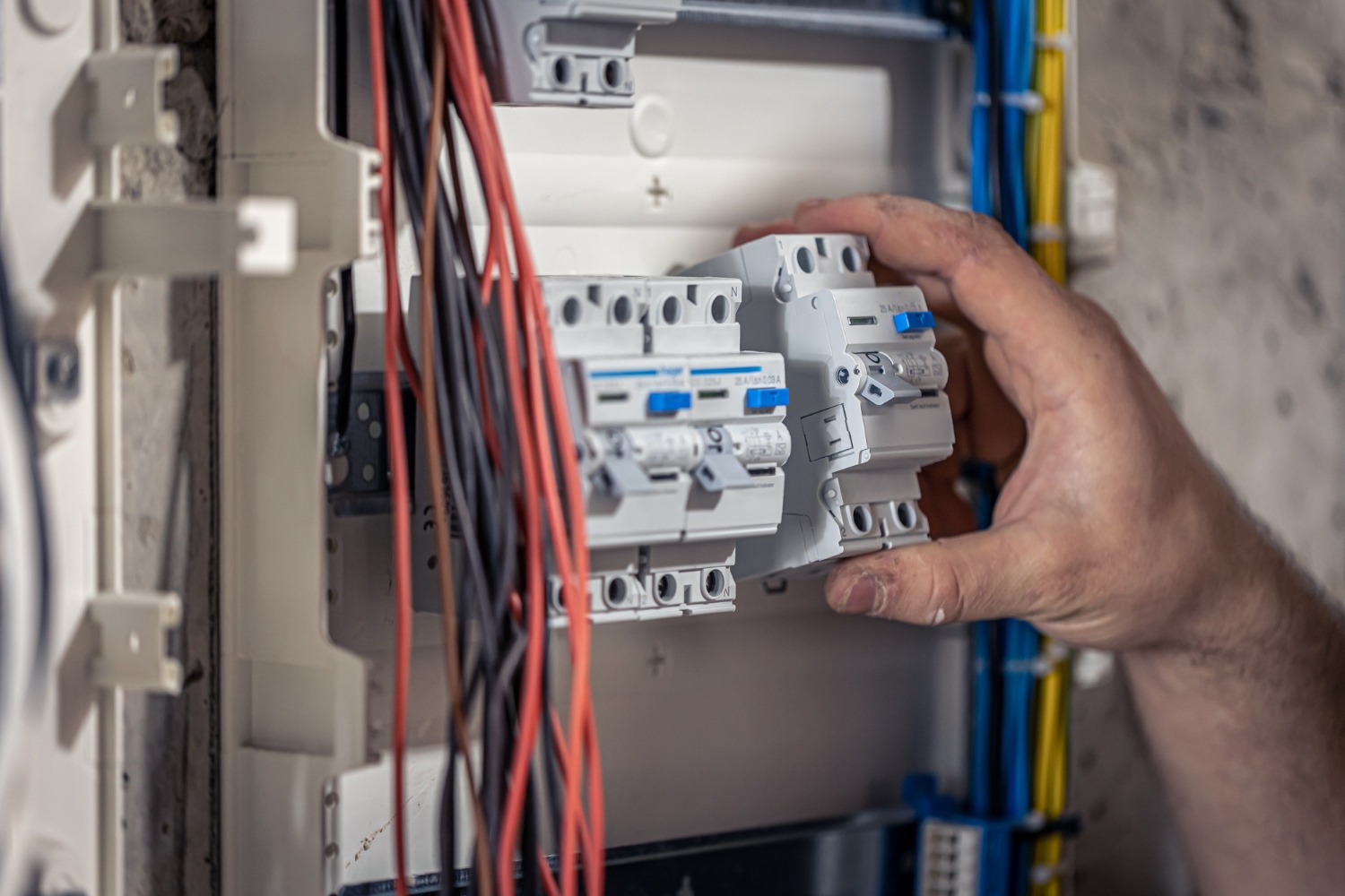 male-electrician-works-switchboard-with-electrical-connecting-cable-2952554