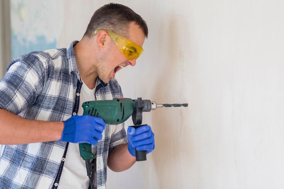 travailleur-faisant-trou-dans-mur_23-2148384424-3745226